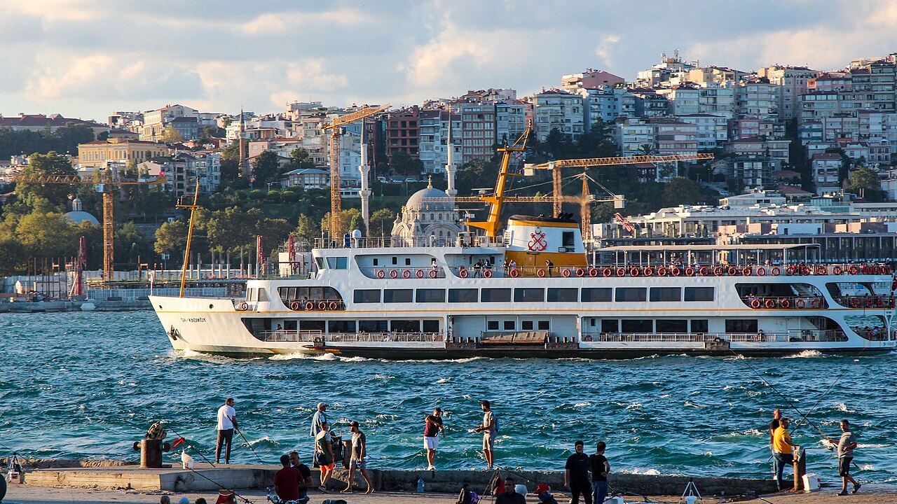 Istanbul ferry crossing the Bosphorus with fishermen in foreground